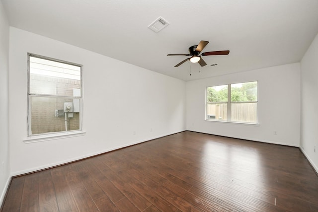unfurnished room featuring dark wood finished floors, baseboards, ceiling fan, and visible vents
