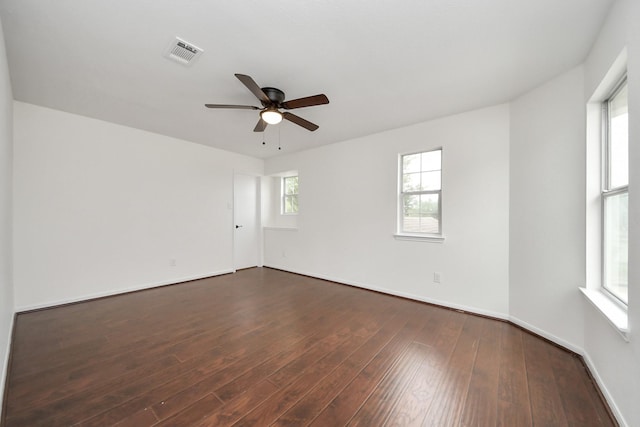 unfurnished room with baseboards, visible vents, dark wood-type flooring, and a ceiling fan