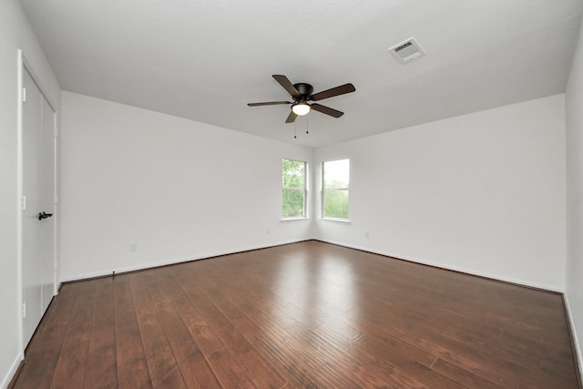 empty room with hardwood / wood-style floors, baseboards, ceiling fan, and visible vents