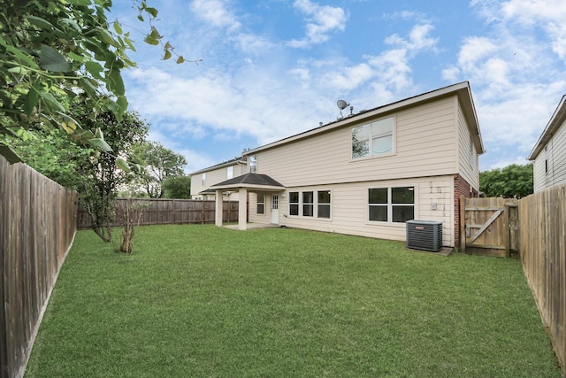 back of house with a fenced backyard, central AC, and a lawn