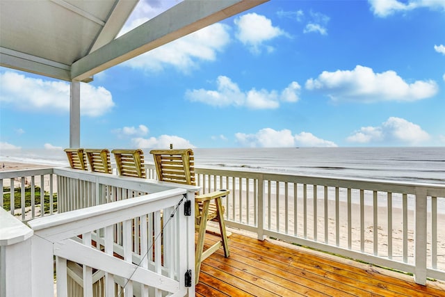 wooden deck featuring a view of the beach and a water view