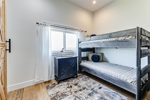 bedroom featuring baseboards, light wood-type flooring, and recessed lighting