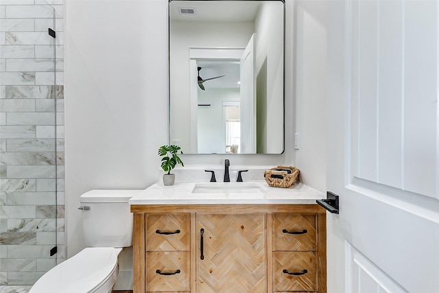 bathroom with toilet, vanity, and visible vents