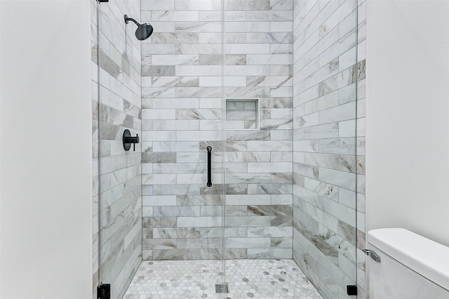 full bath featuring a shower stall and toilet