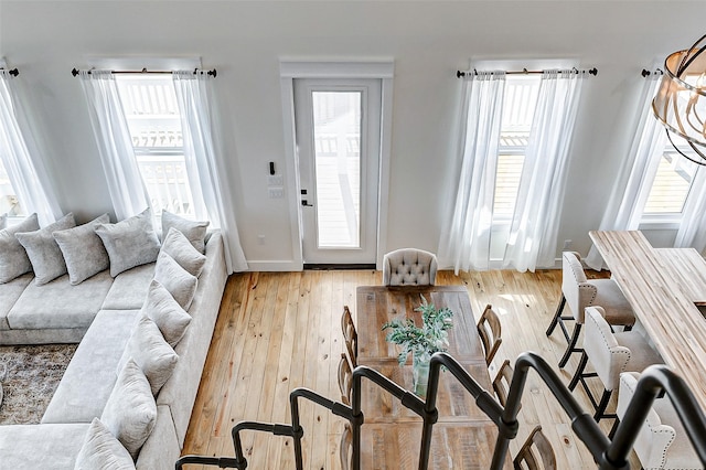 living area featuring light wood-style flooring, plenty of natural light, and baseboards