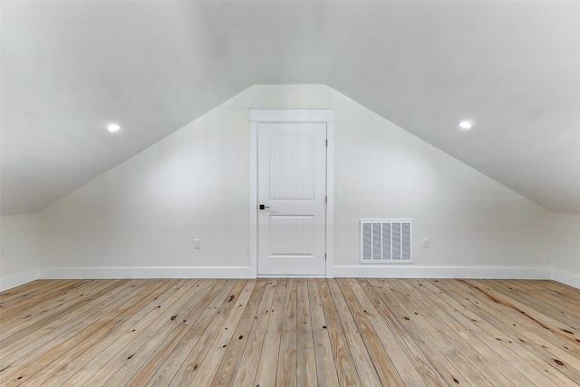 bonus room with baseboards, lofted ceiling, visible vents, and light wood-type flooring
