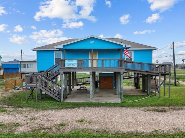818 Surf Dr, Surfside Beach, TX 77541 - view of front facade with stairway, a carport, a patio area, and roof with shingles