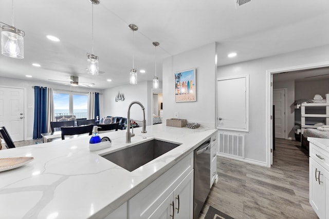 7600 Seawall Blvd Unit 214, Galveston, TX 77551 - kitchen featuring stainless steel dishwasher, recessed lighting, hanging light fixtures, light wood-style floors, and white cabinets
