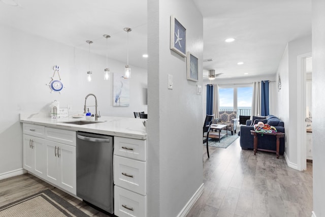 7600 Seawall Blvd Unit 214, Galveston, TX 77551 - kitchen featuring dishwasher, light wood-style flooring, white cabinets, light stone countertops, and open floor plan
