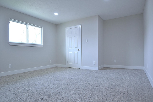 unfurnished room featuring recessed lighting, carpet, baseboards, and a textured ceiling