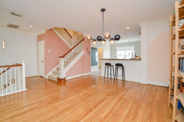 208 Bremond St, Houston, TX 77006 - unfurnished living room with crown molding, baseboards, visible vents, and light wood-style flooring