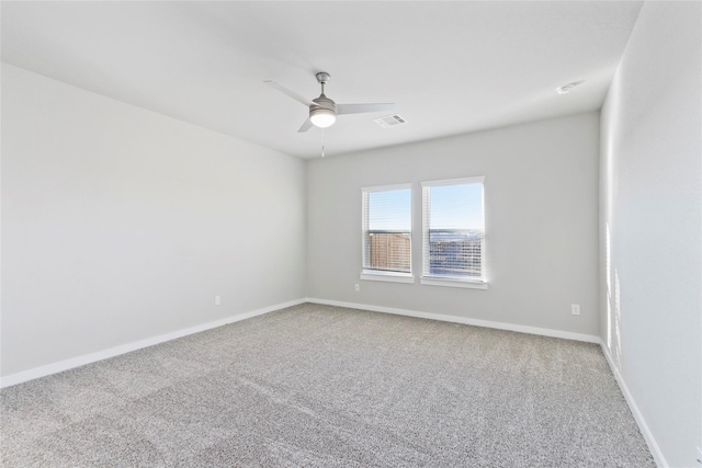 carpeted empty room featuring baseboards, visible vents, and a ceiling fan