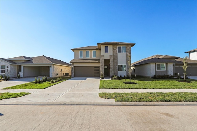 prairie-style home with a garage, driveway, stucco siding, and a front lawn
