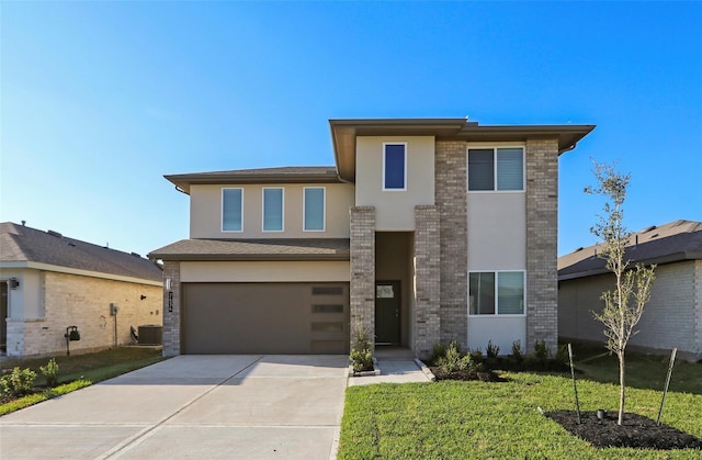 view of front of property with driveway, a front yard, stucco siding, brick siding, and a garage