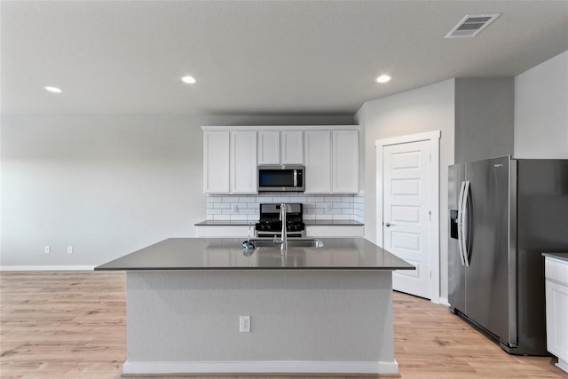 kitchen with white cabinets, visible vents, light wood finished floors, appliances with stainless steel finishes, and a sink