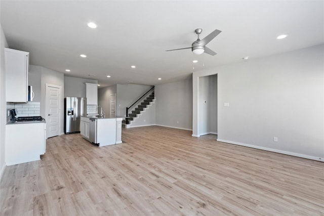 unfurnished living room featuring recessed lighting, a sink, light wood-style floors, and ceiling fan