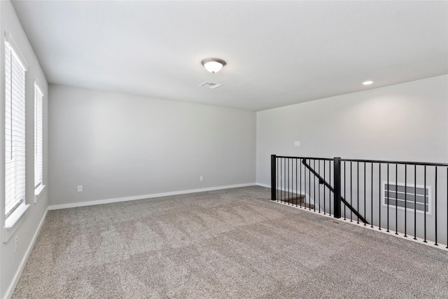 carpeted empty room featuring recessed lighting, baseboards, and visible vents