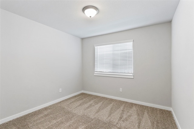 carpeted empty room featuring baseboards