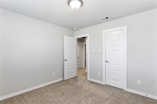 unfurnished bedroom with light carpet, baseboards, and visible vents