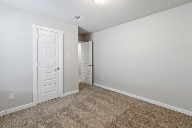 unfurnished bedroom with baseboards, carpet floors, and visible vents