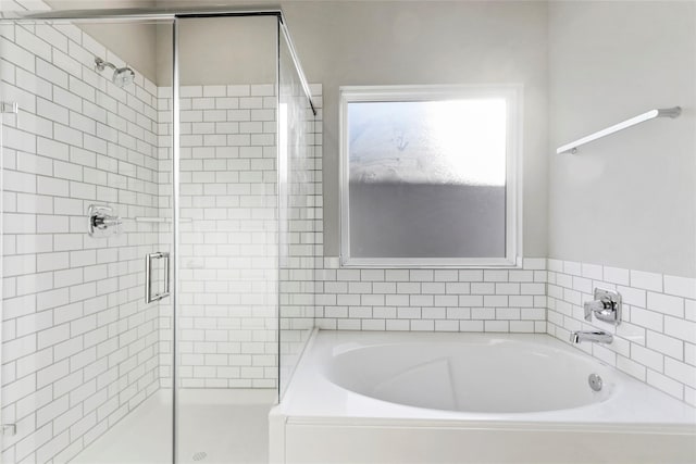 full bathroom featuring a garden tub and a stall shower