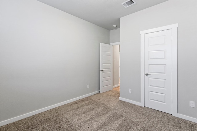 unfurnished bedroom with carpet floors, baseboards, and visible vents