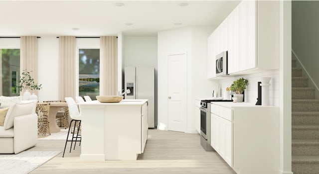 kitchen with a kitchen island with sink, a kitchen bar, stainless steel microwave, white fridge with ice dispenser, and stove