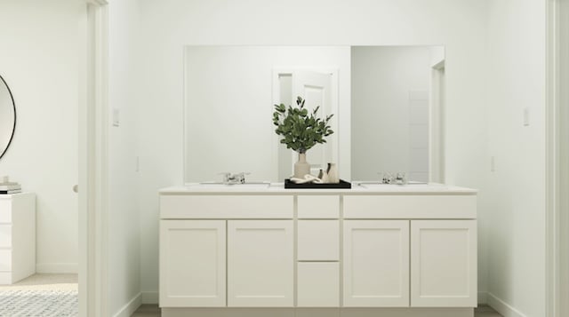 bathroom with baseboards, double vanity, and a sink