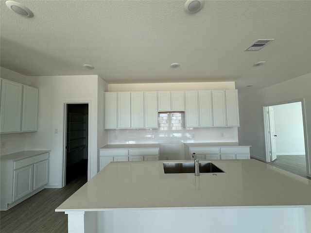 9318 Vendace Dr, Baytown, TX 77521 - kitchen with a sink, an island with sink, tasteful backsplash, wood finished floors, and a textured ceiling