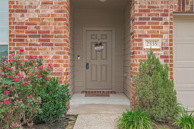 property entrance featuring brick siding