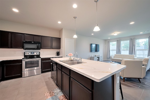 kitchen with light tile patterned floors, black appliances, open floor plan, and a sink