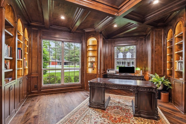 office space featuring built in shelves, dark wood-type flooring, wooden walls, wood ceiling, and ornamental molding