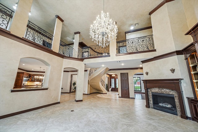 unfurnished living room with a high ceiling, arched walkways, and a chandelier