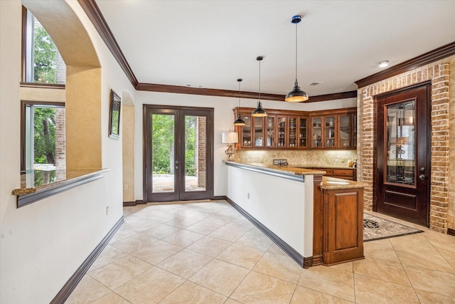 kitchen featuring light stone countertops, glass insert cabinets, light tile patterned flooring, and a peninsula