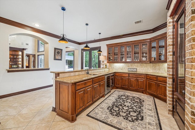 kitchen with brown cabinets, tasteful backsplash, beverage cooler, visible vents, and a peninsula