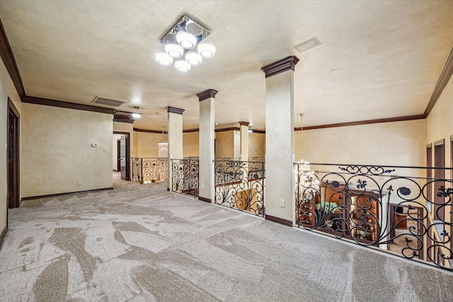 spare room with ornamental molding, visible vents, carpet flooring, and ornate columns