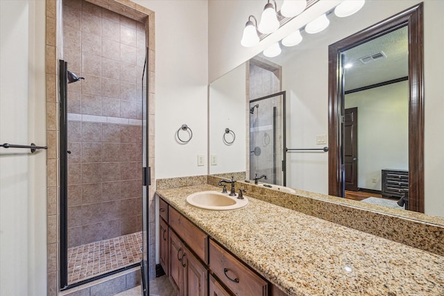 full bathroom with a stall shower, visible vents, and vanity