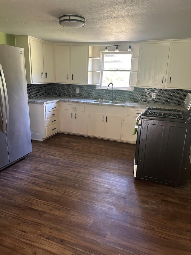 304 Tanner Ave, Cleveland, TX 77327 - kitchen with freestanding refrigerator, range with gas stovetop, a sink, decorative backsplash, and open shelves