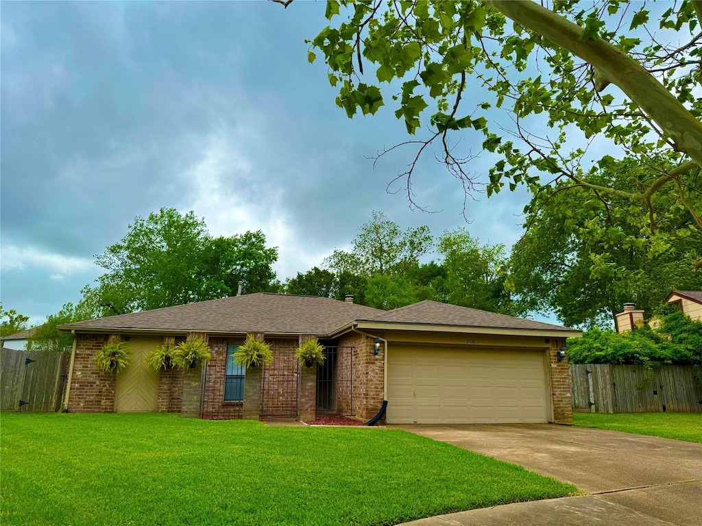 view of front of property with fence, a front lawn, brick siding, a garage, and driveway