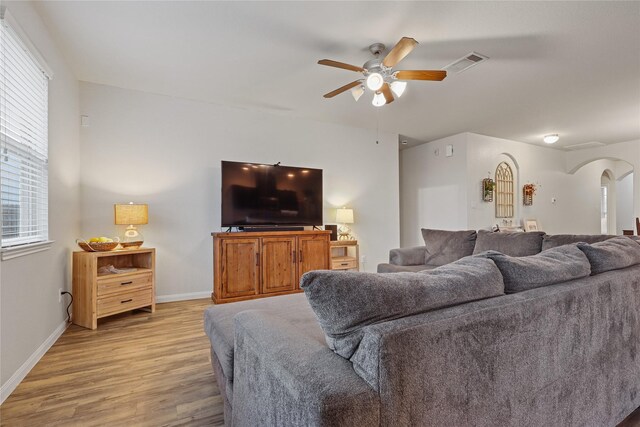 2225 Windy Sail Dr, Texas City, TX 77568 - living area featuring light wood-style flooring, arched walkways, a ceiling fan, visible vents, and baseboards