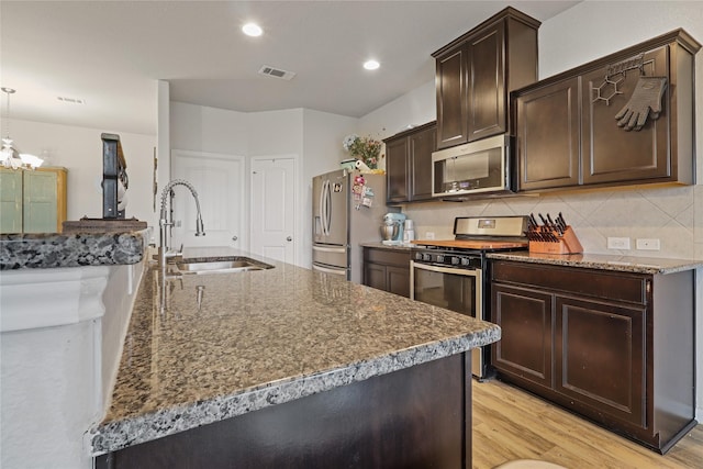 2225 Windy Sail Dr, Texas City, TX 77568 - kitchen featuring a sink, dark brown cabinets, decorative backsplash, and appliances with stainless steel finishes
