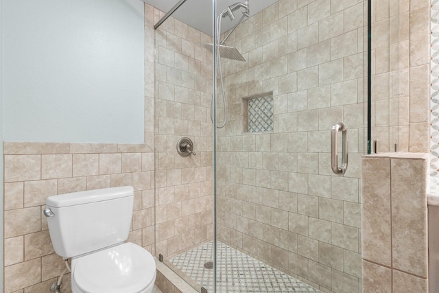 12800 Melville Dr Unit B307, Montgomery, TX 77356 - full bath featuring tile walls, a shower stall, toilet, and wainscoting