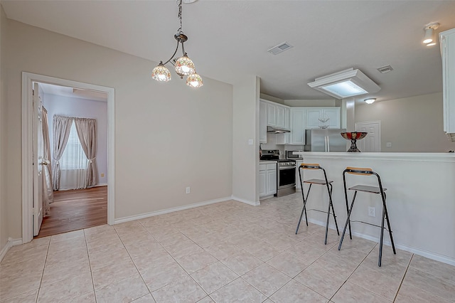 kitchen with visible vents, under cabinet range hood, appliances with stainless steel finishes, and light tile patterned floors