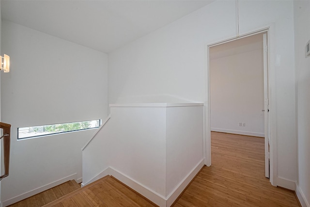 staircase featuring baseboards and wood finished floors