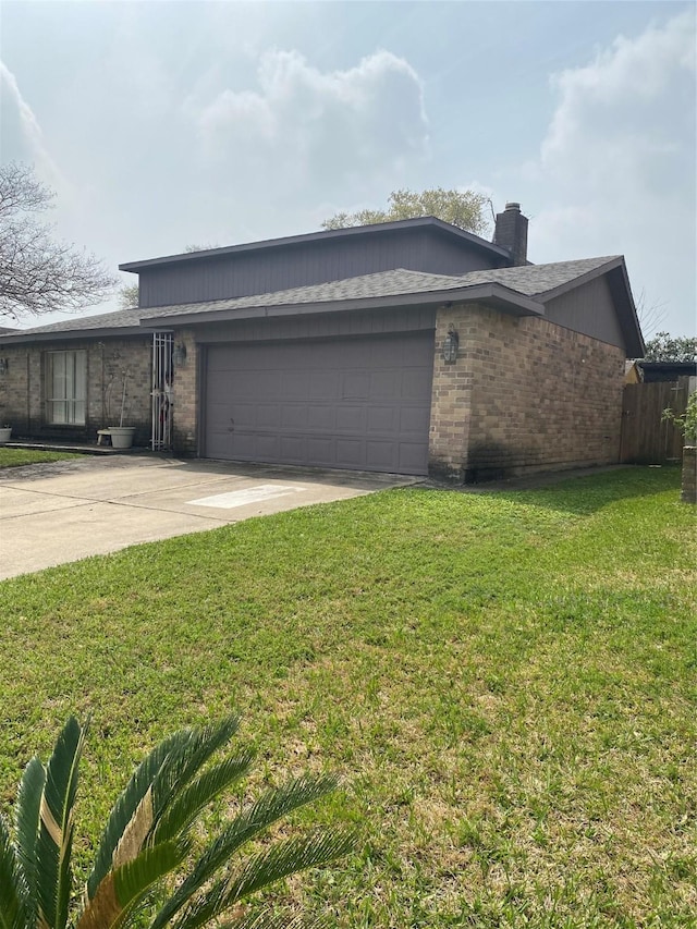 view of side of property with a lawn, driveway, an attached garage, and brick siding