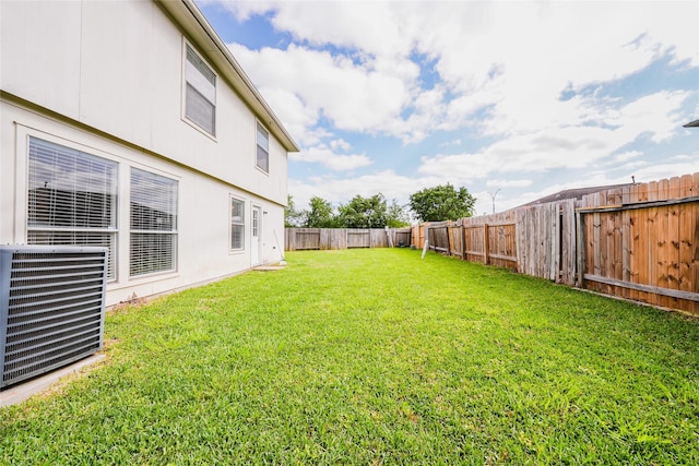 view of yard with central AC unit and a fenced backyard