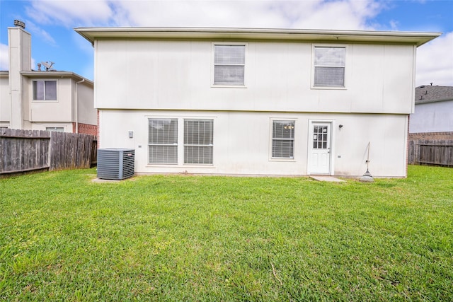 rear view of house with a yard, cooling unit, and a fenced backyard