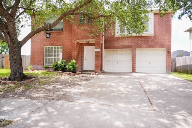 traditional-style home with brick siding, driveway, fence, and a garage