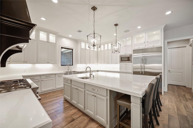 27415 Siandra Creek Ln, Spring, TX 77386 - kitchen with built in appliances, a sink, a chandelier, an island with sink, and white cabinetry