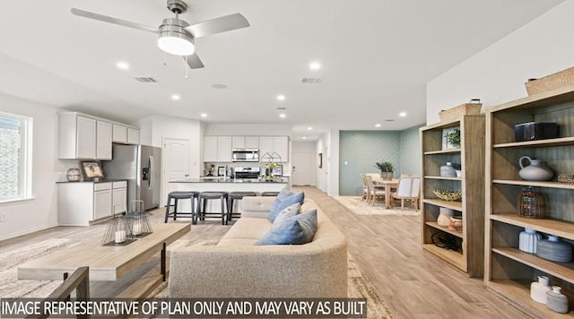 living area with visible vents, ceiling fan, recessed lighting, and light wood-style flooring